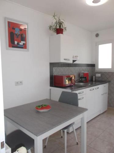 a kitchen with a table and a counter top at Chez Yolande in Angles