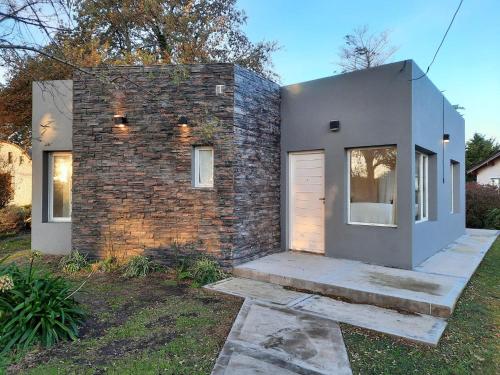 a brick house with a garage in a yard at Casa 3 ambientes in Balneario Mar Chiquita