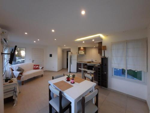 a kitchen and living room with a white table and chairs at Casa 3 ambientes in Balneario Mar Chiquita