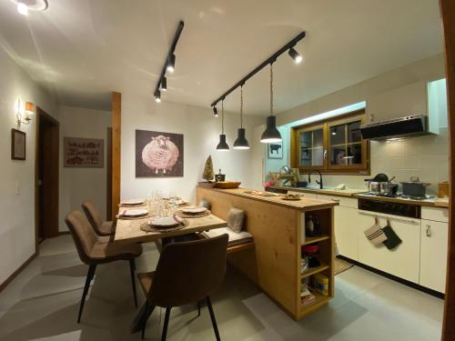 a kitchen with a wooden table and chairs in it at Wonderful apartment overlooking the Swiss alps in Chateau-d'Oex