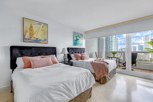 um quarto com 2 camas e uma varanda em Bayfront Gem with Balcony and Pool em Miami