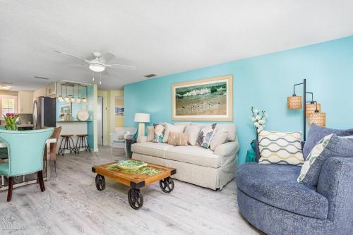 ein Wohnzimmer mit einem Sofa und einem Tisch in der Unterkunft Lulu's Crescent Cottage #1 in Sarasota