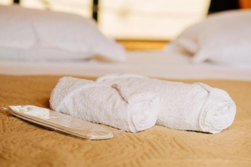 a white towel sitting on top of a bed at Oda Riverside Cottages in Aragvispiri
