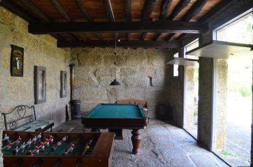 a pool table in a room with a stone wall at Casal do Outeiro by LovelyStay in Marco de Canaveses