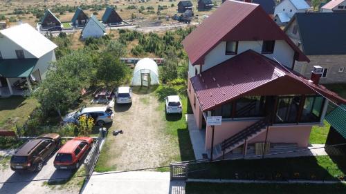 una vista aerea di una casa con auto parcheggiate in un cortile di Deluxe Studio & Rooms Zarubica a Žabljak