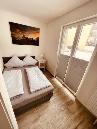 a bedroom with a bed and a large window at Ferienwohnungen Mey Haus zum Rosenstock in Erfurt