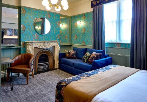 una camera con letto, divano e specchio di Alderley Edge Hotel ad Alderley Edge