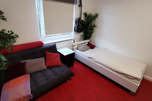 Zimmer mit einem Bett, einem Sofa und einem Fenster in der Unterkunft Private Apartment in Hannover