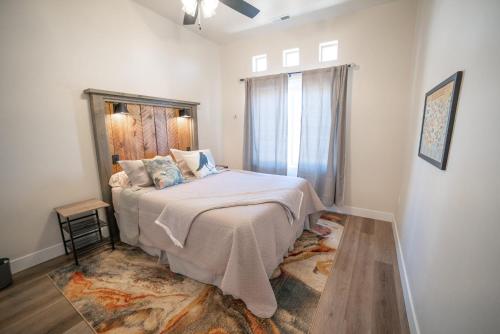 Schlafzimmer mit einem großen Bett und einem Fenster in der Unterkunft Hollywood Hangout - New West Properties in Kanab