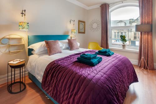 a bedroom with a large bed with a purple blanket at Albert Road Apartments Flat 2 in Colne