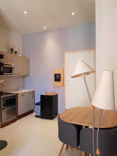 - une cuisine avec une table et une lampe dans une pièce dans l'établissement le petit chalet de Grenoble, à Grenoble