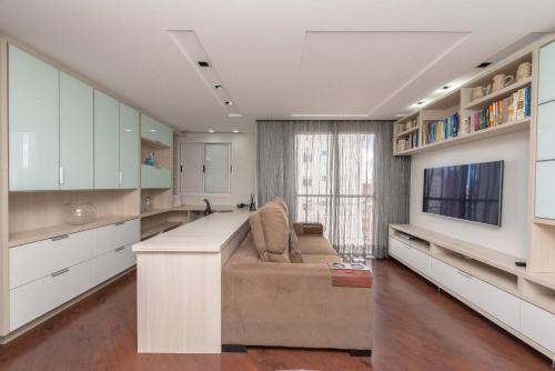 a large living room with a couch and a tv at Condominio Felice Club in Curitiba
