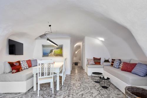 Villa Agalitsa Cave Houses with Garden Courtyard في ميغالوخوري: غرفة معيشة مع أريكة وطاولة