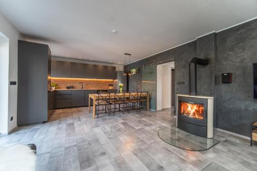 a living room with a fireplace and a kitchen at Holiday House Adonis in Bystřice