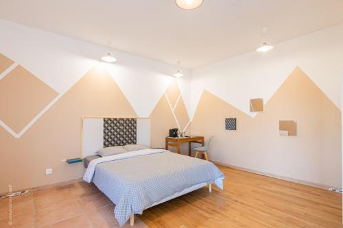 - une chambre avec un lit aux formes géométriques sur le mur dans l'établissement Logis de beauce, 