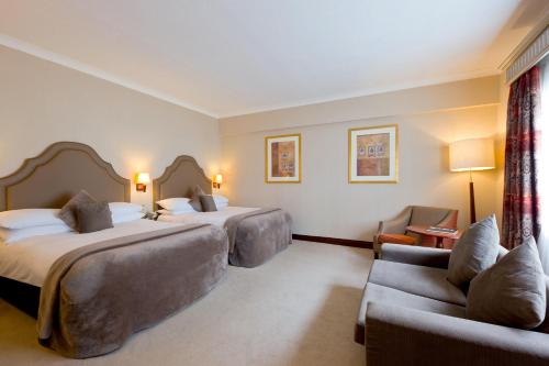 a hotel room with two beds and a couch at Fitzpatrick Castle Hotel in Dalkey