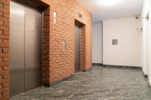 un corridoio con un muro di mattoni e due porte di Great Tourist and Business Apartment a Bratislava