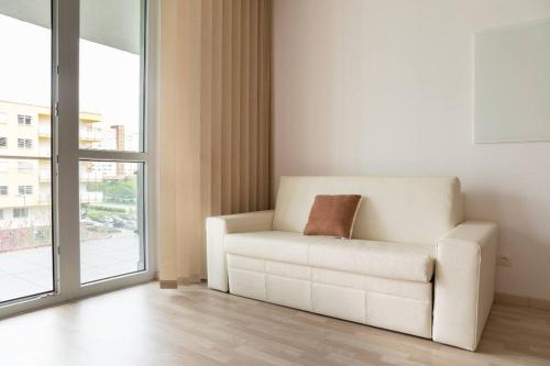 un divano bianco in un soggiorno con finestra di Great Tourist and Business Apartment a Bratislava