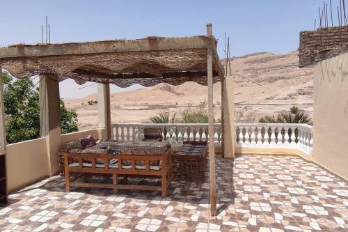 un patio con una mesa de madera. en Tibs mountain view en Al Aqālitah