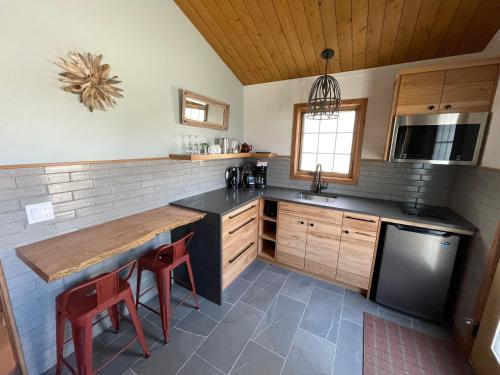 a kitchen with a wooden table and a black refrigerator at Bear Hill Lodge in Jasper