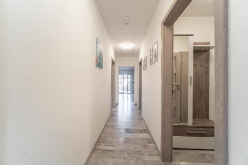 a hallway with white walls and wooden floors at Holiday House Adonis in Bystřice