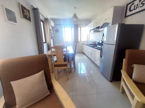 a kitchen and living room with a refrigerator and a table at Superb Apartment 2 mins to Beach in Flic-en-Flac