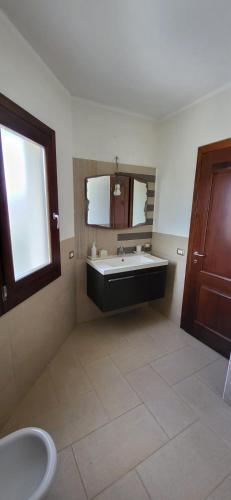a bathroom with a tub and a sink and a window at Mi Casita in Arzachena