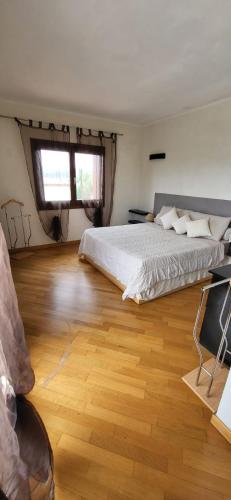 a bedroom with a large bed and a wooden floor at Mi Casita in Arzachena