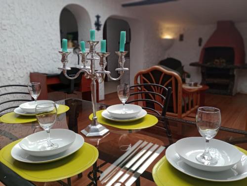 una mesa de comedor con platos amarillos y copas de vino en Hatuchay Inka Apart Hotel en Cajamarca