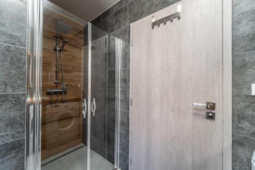 a shower with a glass door in a bathroom at Holiday House Adonis in Bystřice
