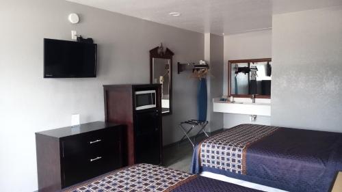 Habitación de hotel con cama y lavabo en Coachman's Inn & Suites en Waldron