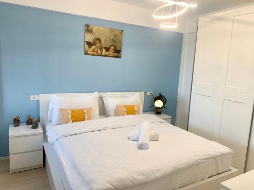 una camera con un letto bianco e una parete blu di JAD - Comfortable Family Apartments - Coresi a Braşov