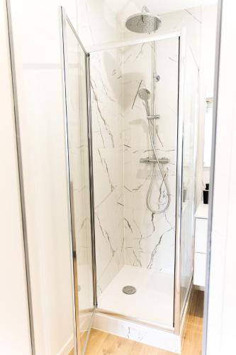 une cabine de douche avec une porte vitrée dans une salle de bain dans l'établissement Le moderne - Beau T2 - Belle vue sur les quais - Centre - Tram, au Mans
