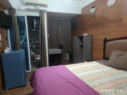 1 dormitorio con 1 cama con manta rosa y ventana en APARTEMEN GRAND DHIKA 2325 BEKASI TIMUR, en Padurenan