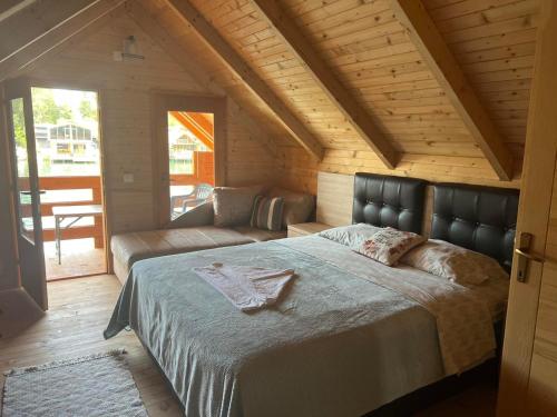 - une chambre avec un grand lit et un canapé dans l'établissement Cheerful cabin in Ada bojana, à Ulcinj