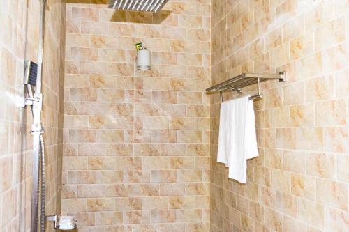 uma casa de banho com um chuveiro e uma toalha branca em Yala Hotel Elephant Eye em Tissamaharama