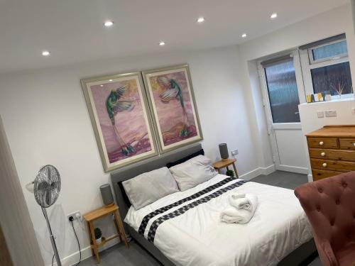 a bedroom with a bed and a fan at Skylight Deluxe Apartment with free parking, close to Windsor, Legoland and Heathrow in Farnham Royal