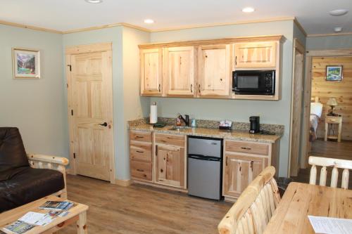 a kitchen with wooden cabinets and a living room at Vista Lodge Benton PA near Ricketts Glen State Park in Benton