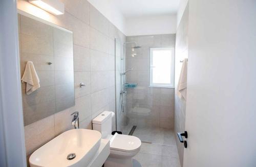 een witte badkamer met een toilet en een wastafel bij Nissi Cube 4 KB4 in Ayia Napa