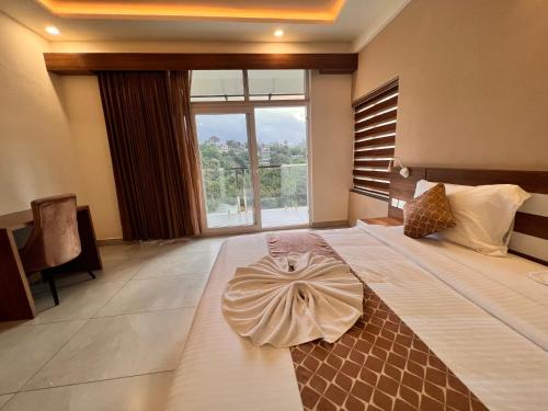 a bedroom with a large bed with a large window at Blue Peaks Holiday Home Munnar in Munnar