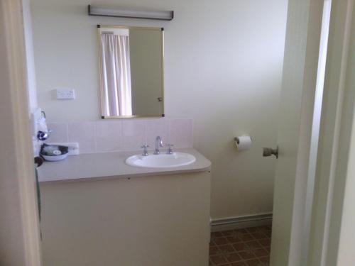 a bathroom with a sink and a mirror at Snowy River Lodge Motel in Orbost