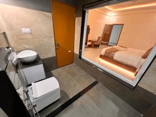 a bathroom with a mirror and a bed and a sink at Blue Peaks Holiday Home Munnar in Munnar
