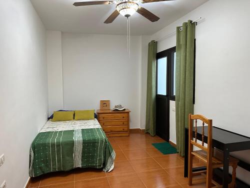 a bedroom with a bed and a table and a ceiling fan at Apartamento Salo in Candelaria