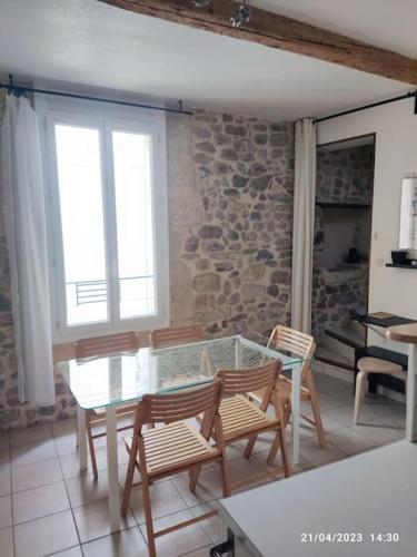 une salle à manger avec une table et des chaises en verre dans l'établissement Duplex du 7, à Bouzigues