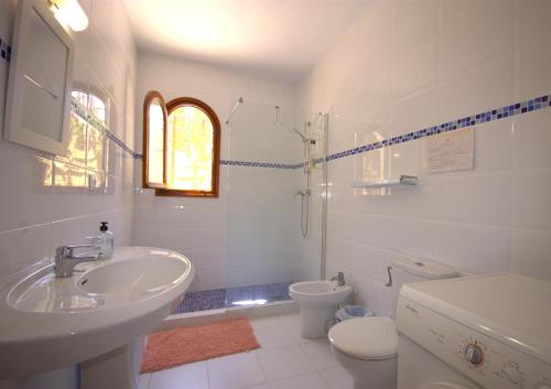 a white bathroom with a sink and a toilet at Holiday Home La Cartuja in Jávea