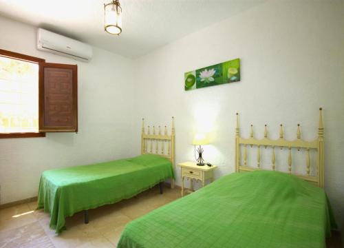 ハベアにあるHoliday Home La Cartujaのベッドルーム1室(緑色のベッド2台、窓付)