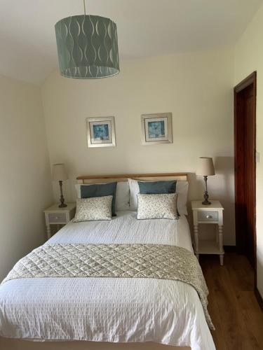 a bedroom with a large bed with two night stands at Baytree Farmhouse in Garryvoe