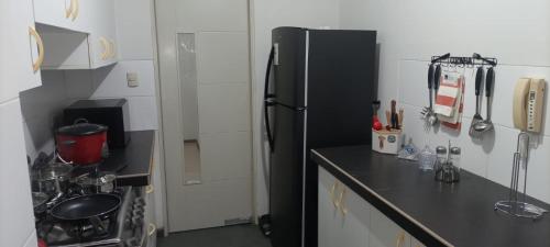 een keuken met een zwarte koelkast en een fornuis bij Apartamento Meta Home zona exclusiva in Piura
