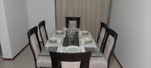 een eettafel met stoelen en een vaas erop bij Apartamento Meta Home zona exclusiva in Piura