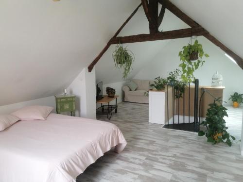 ein Schlafzimmer mit einem weißen Bett und einigen Pflanzen in der Unterkunft Chez Joséphine 
